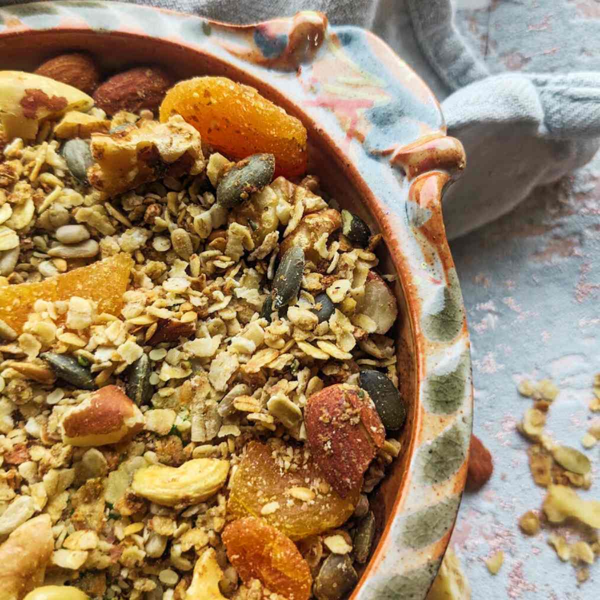 A bowl of homemade granola with chopped apricots on top.