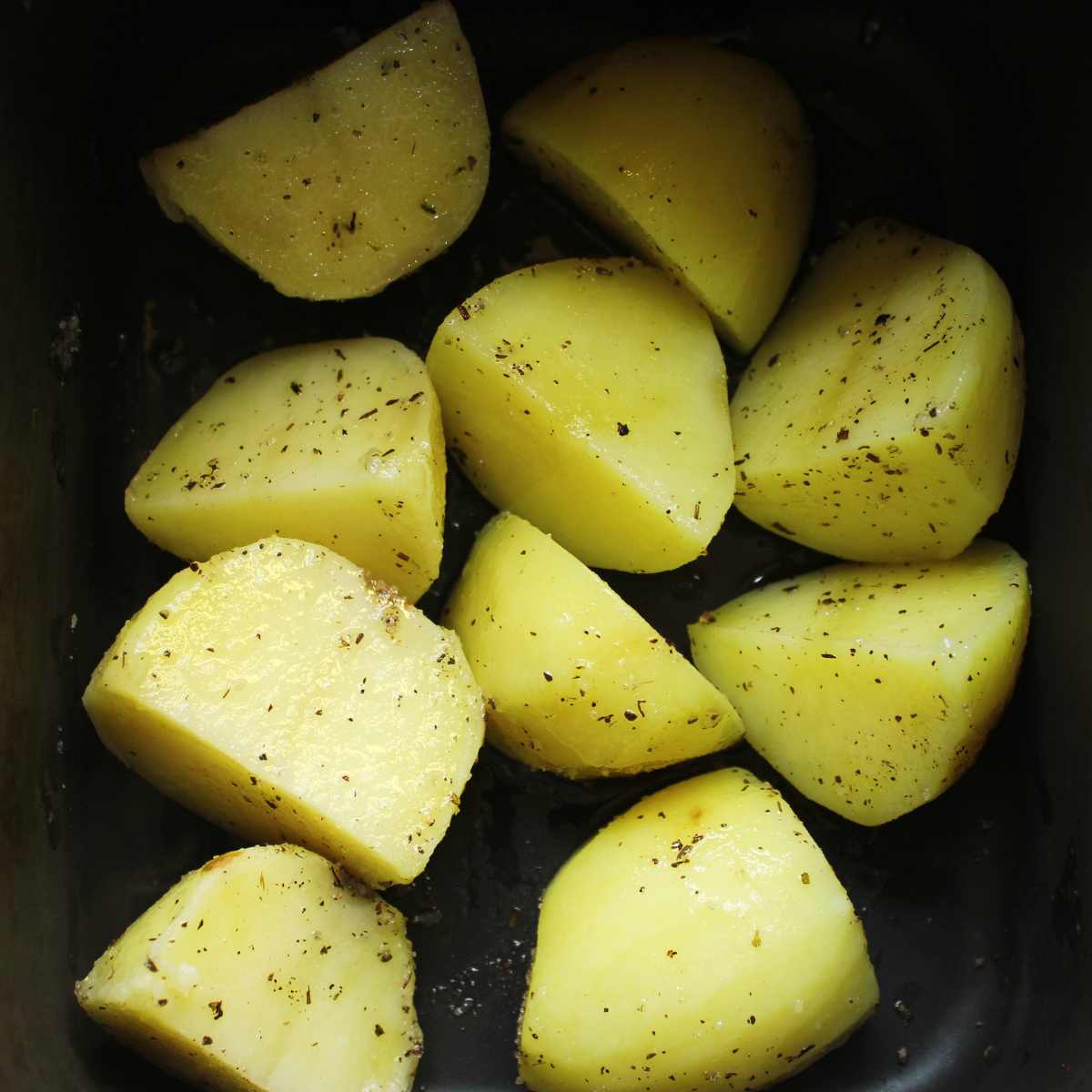 Chopped potatoes in an air fryer basket.