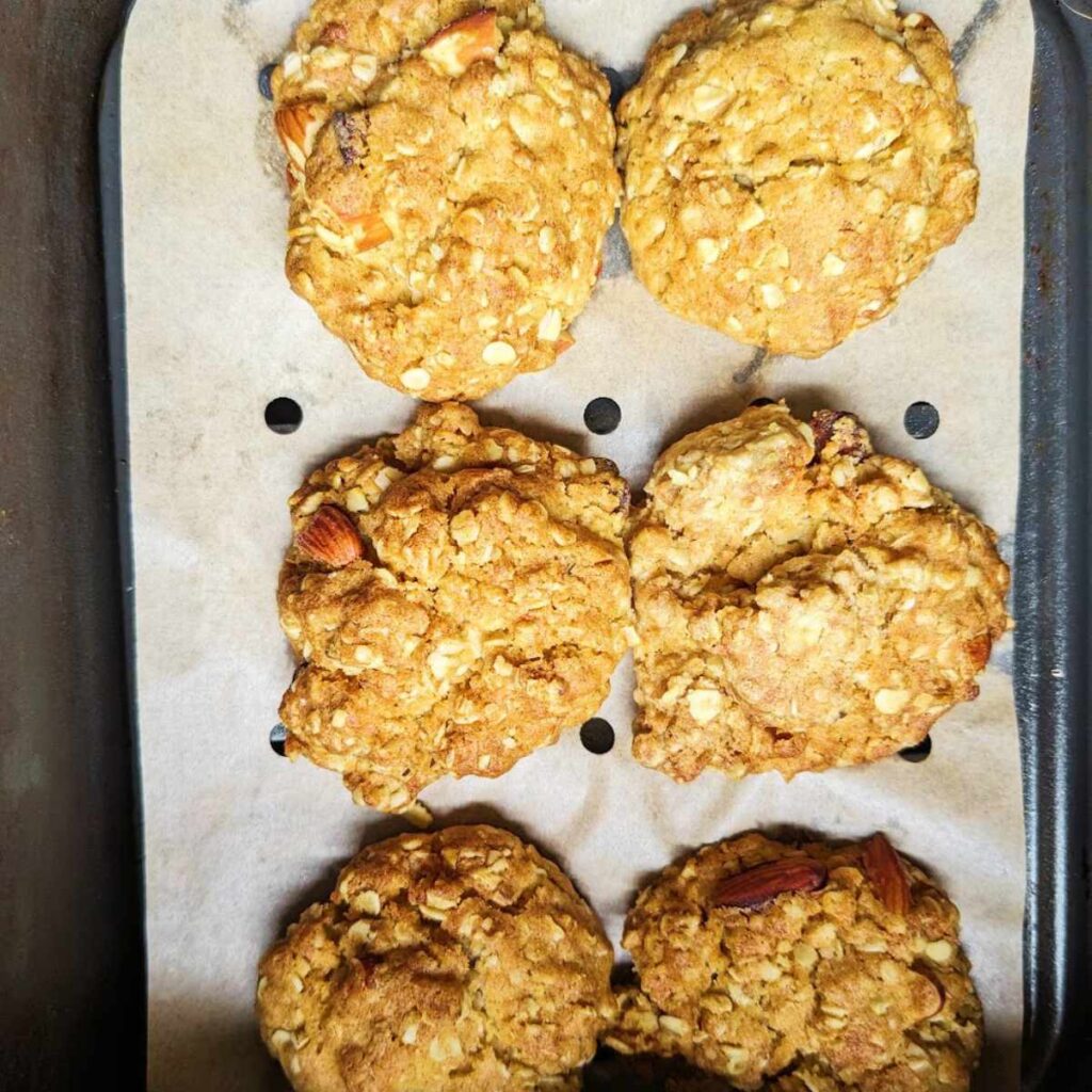 Six cookied cookies in an air fryer basket.