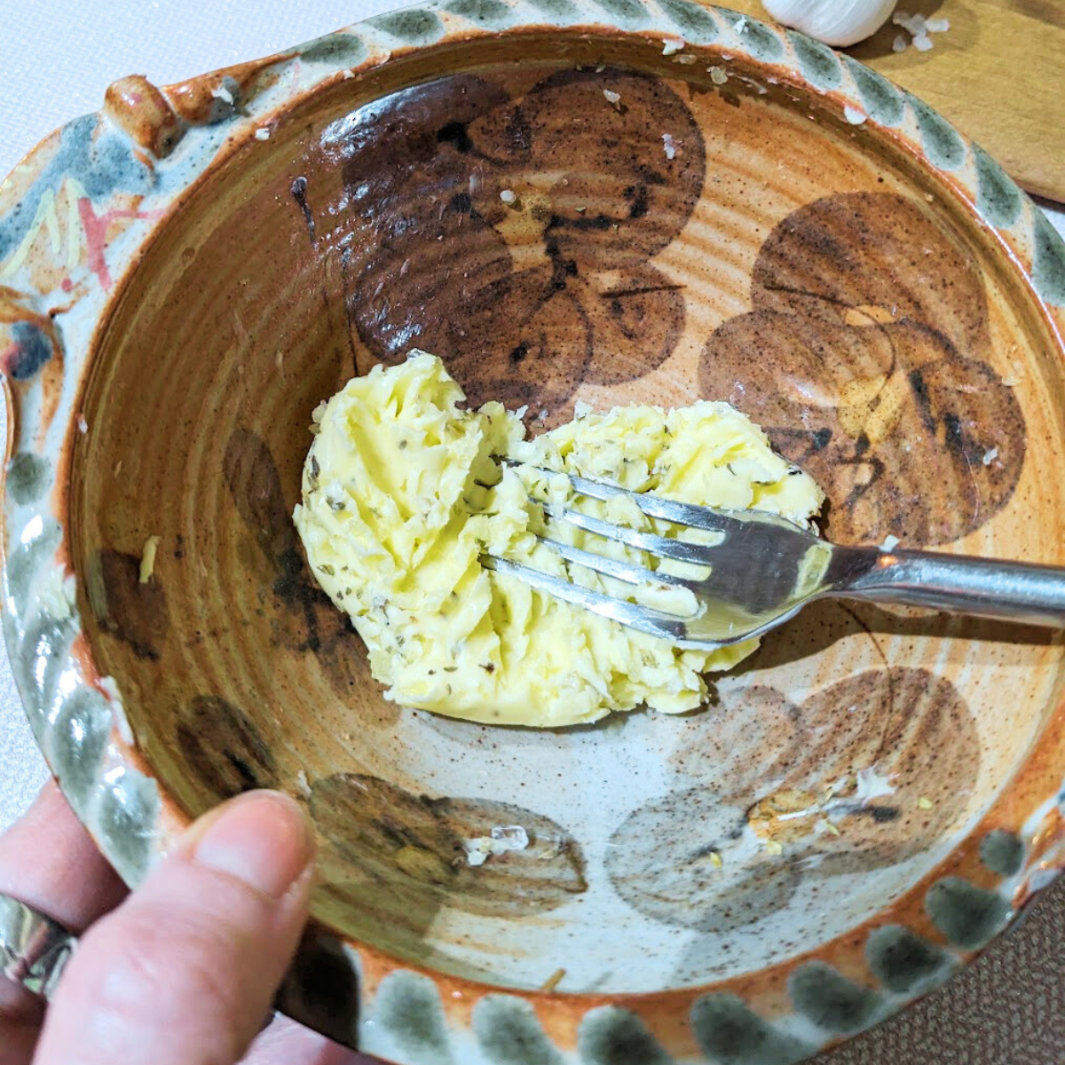 Butter in a bowl being mashed with a fork.