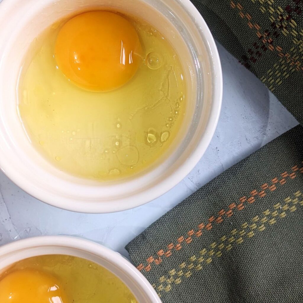Eggs cracked into a ramekin.