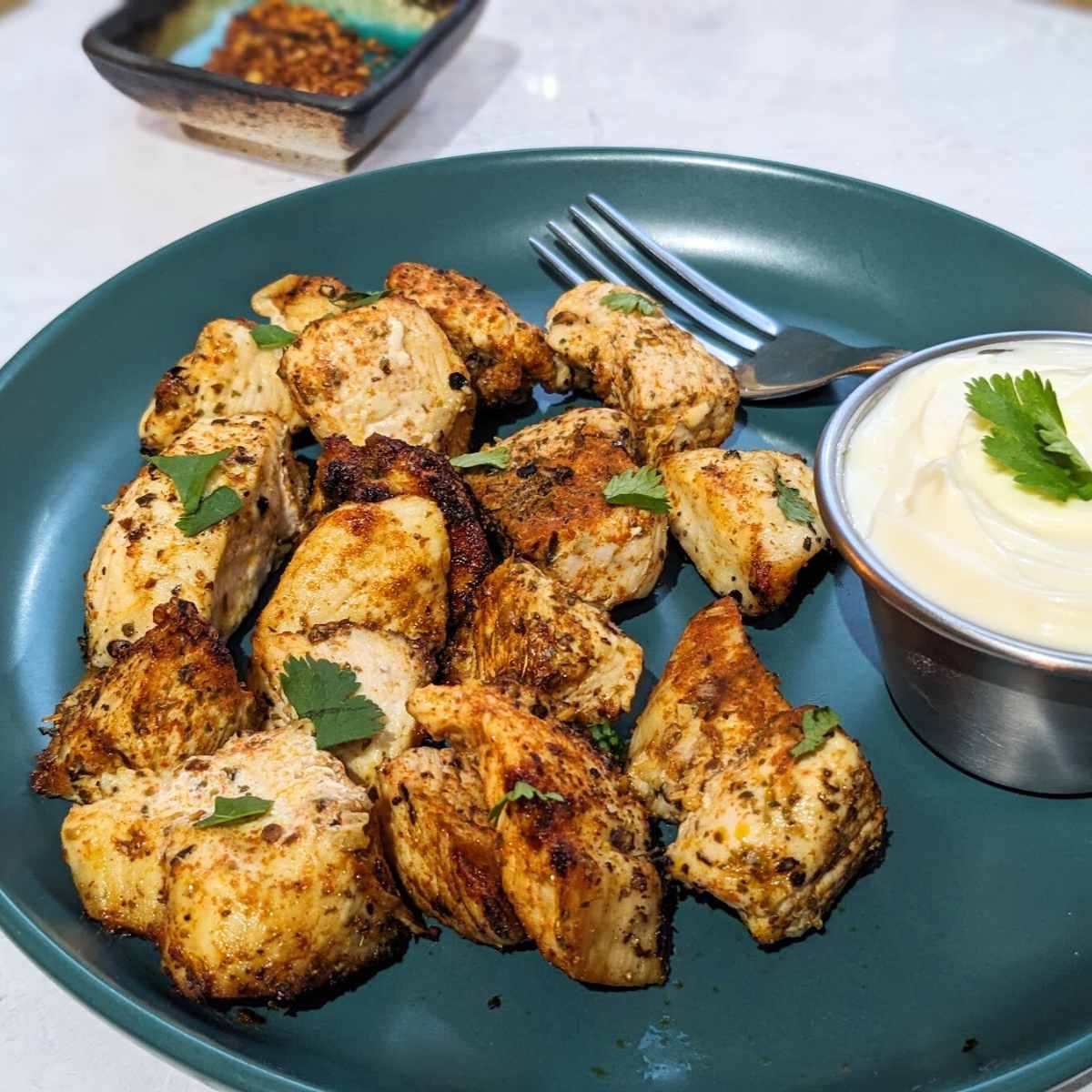 Air Fried chicken bites on a plate with a small bowl of mayo dip.