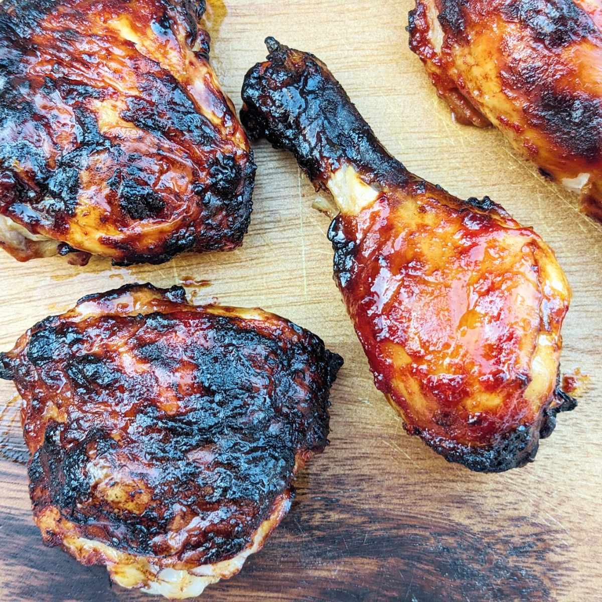 Air fryer bbq chicken wings and thighs, cooked and presented on a wooden board