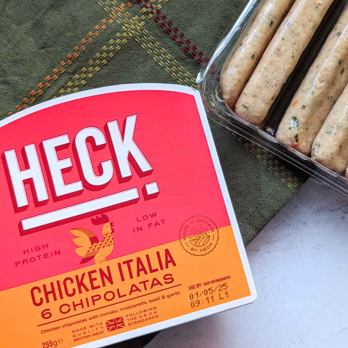 A pack of Heck Chicken sausages with the packaging alongside.