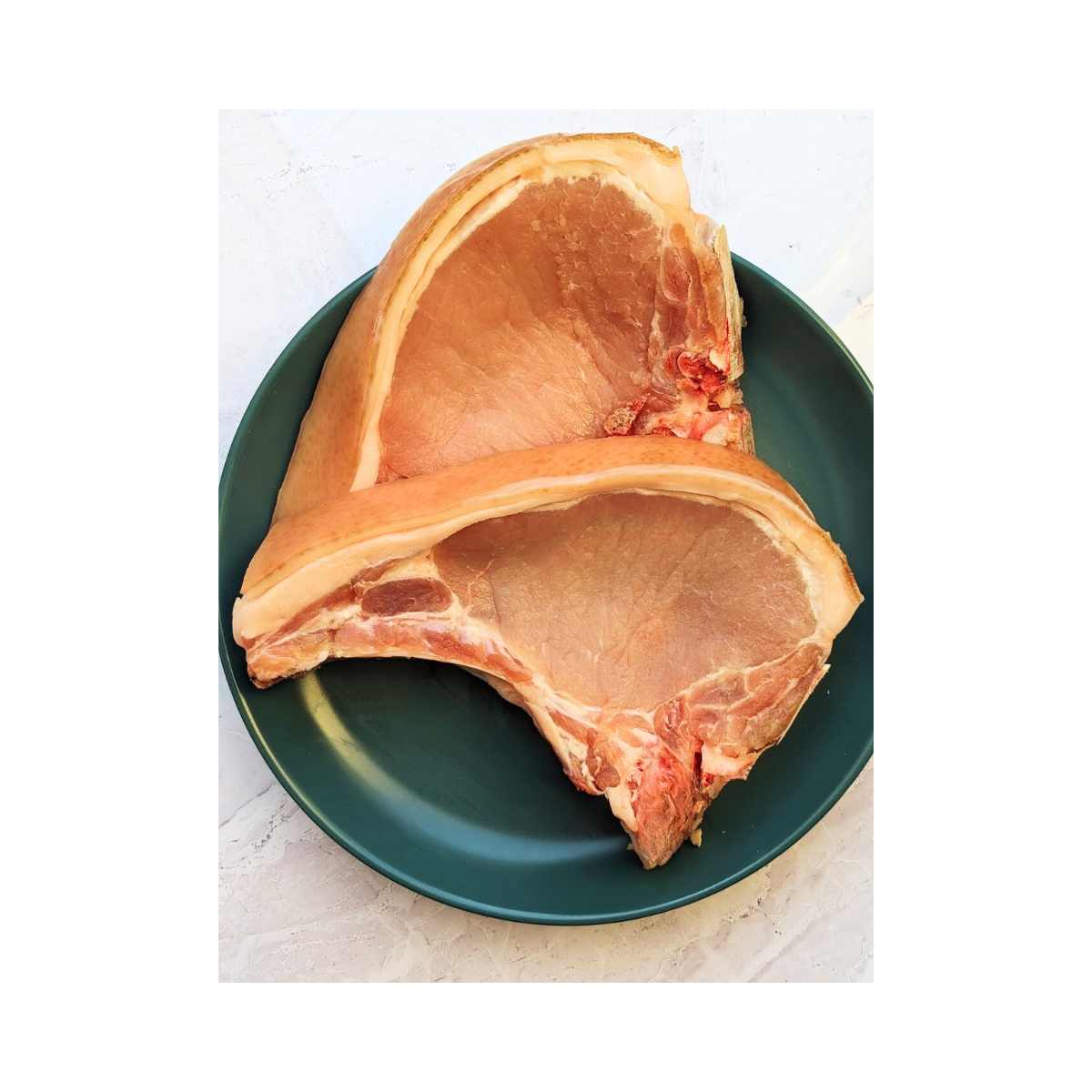 Two pork chops on a blue plate.