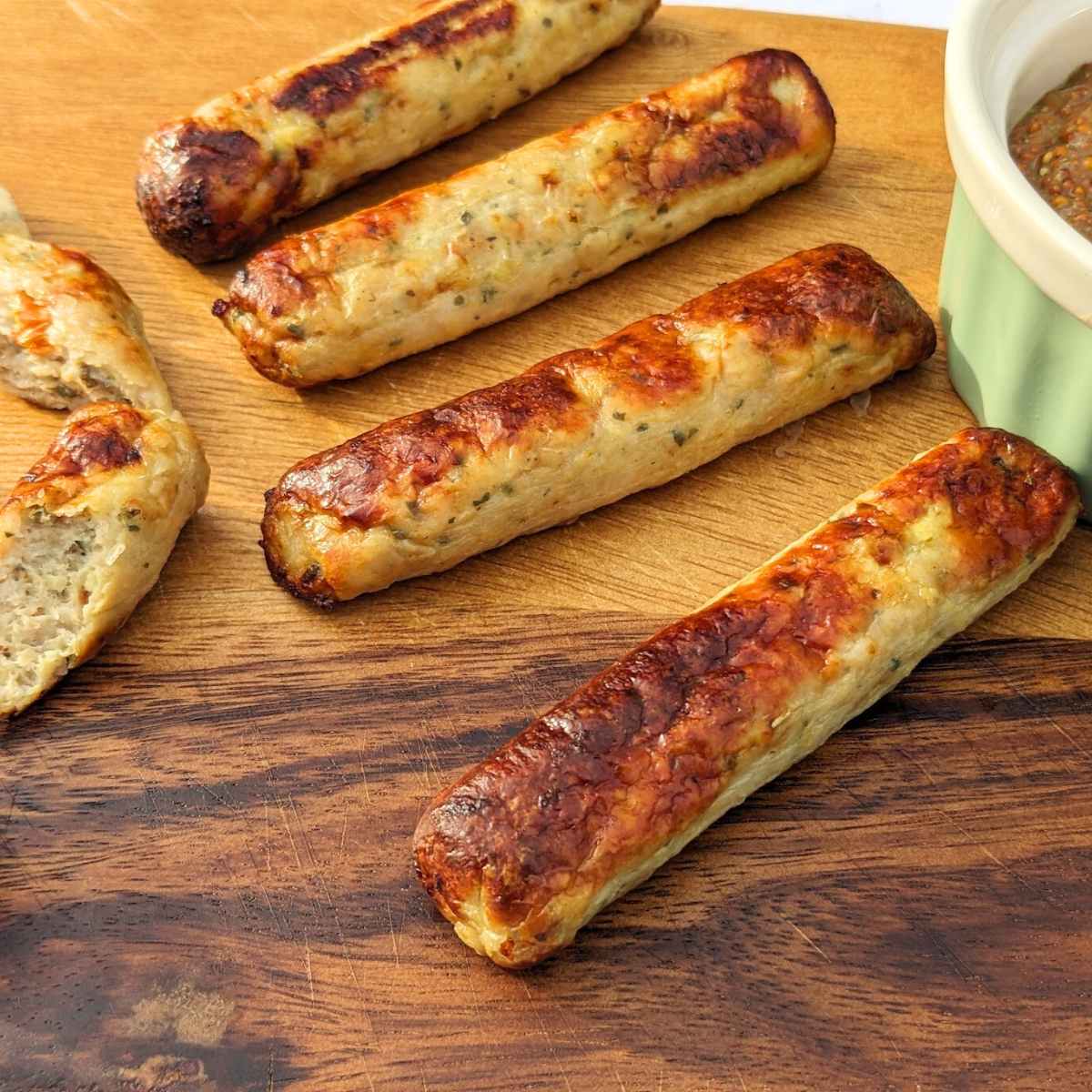 Chicken sausages on a wooden board.