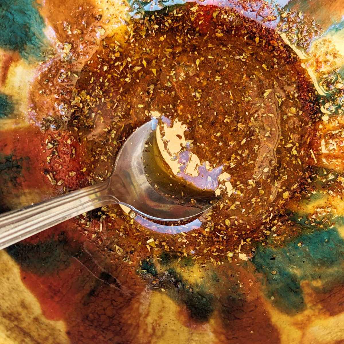A glaze for pork chops in a bowl with a spoon.