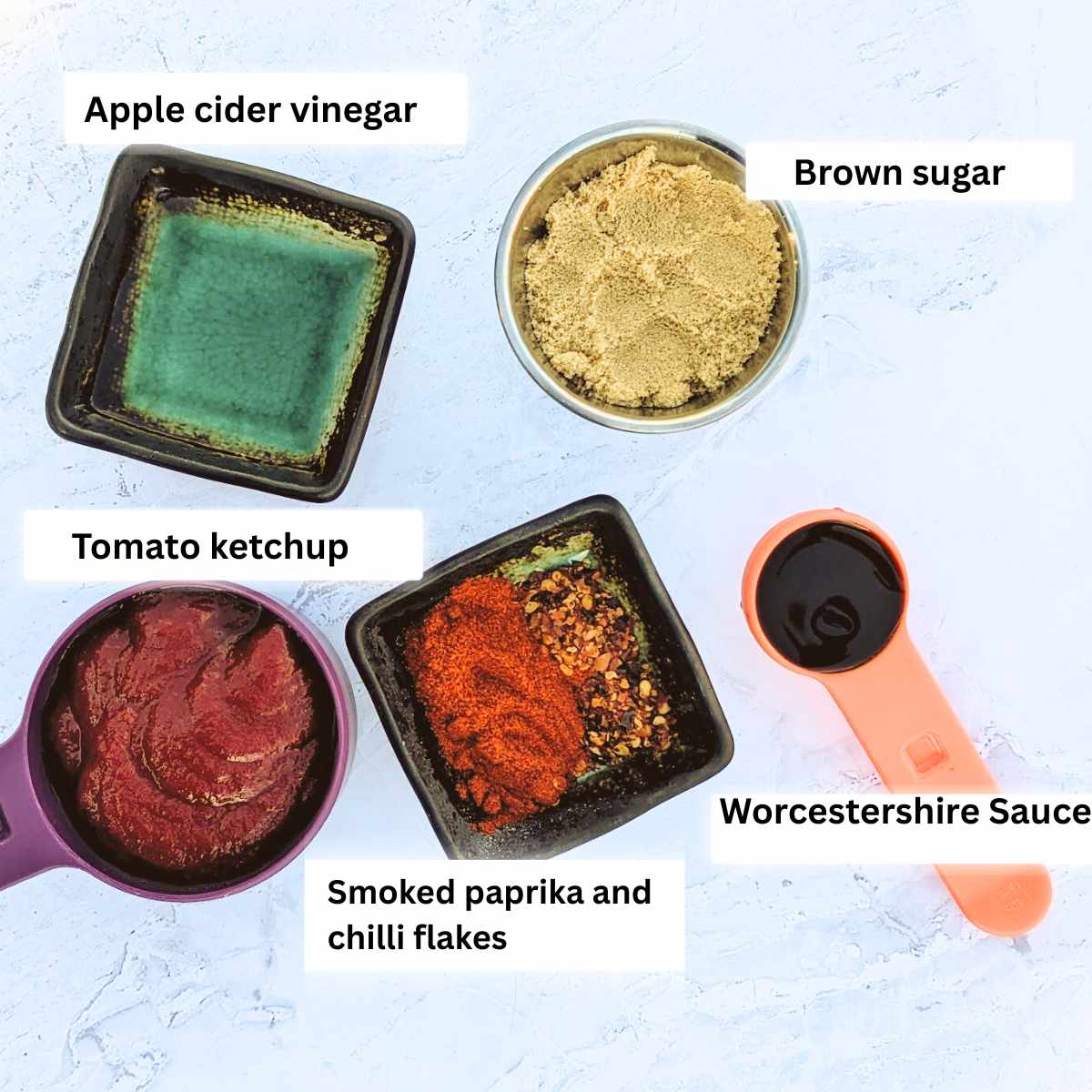 Apple cider vinegar, brown sugar, tomato ketchup, smoked paprika and chilli flakes and Worcestershire sauce portioned out individually to make bbq sauce.