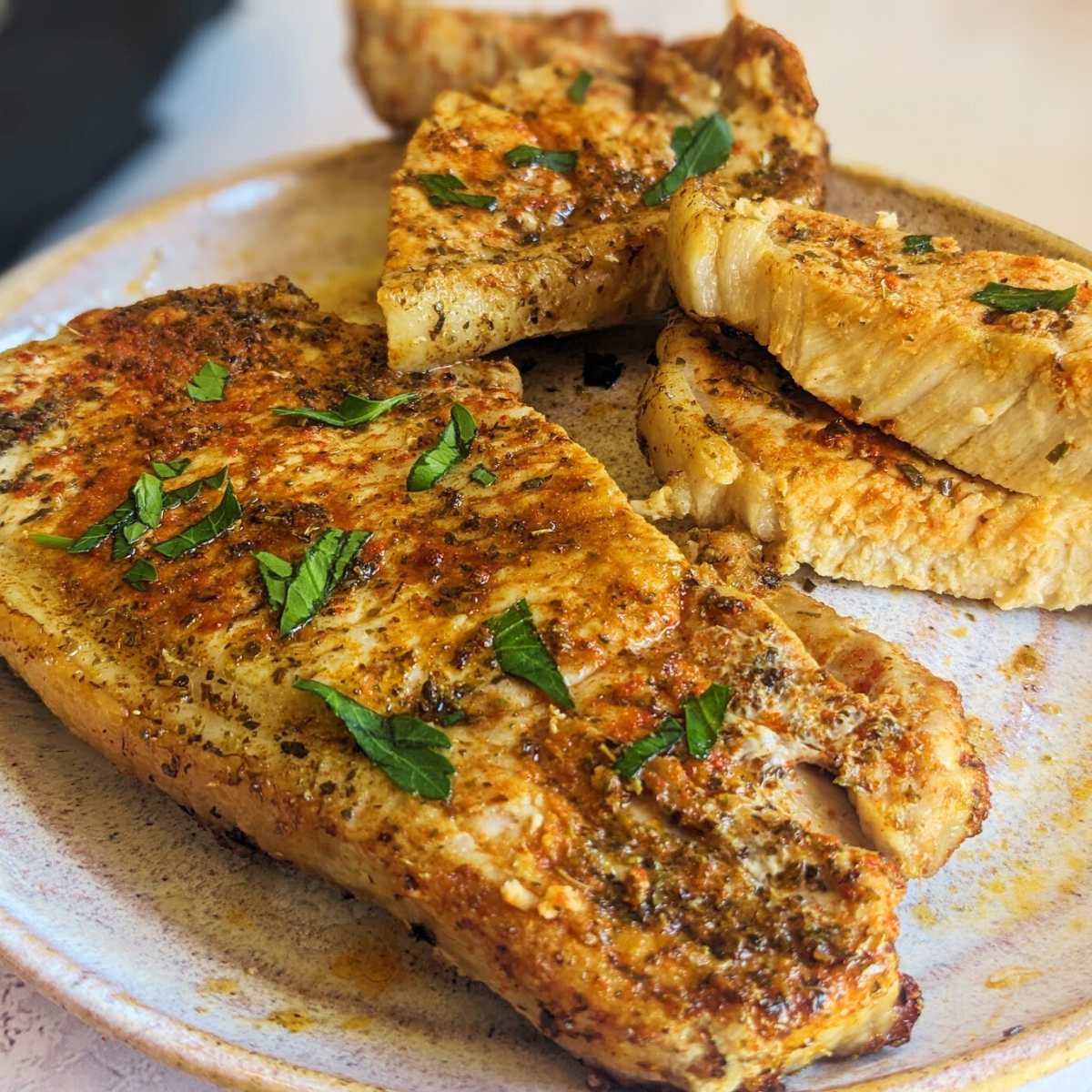 Two thin pork chops on a plate.