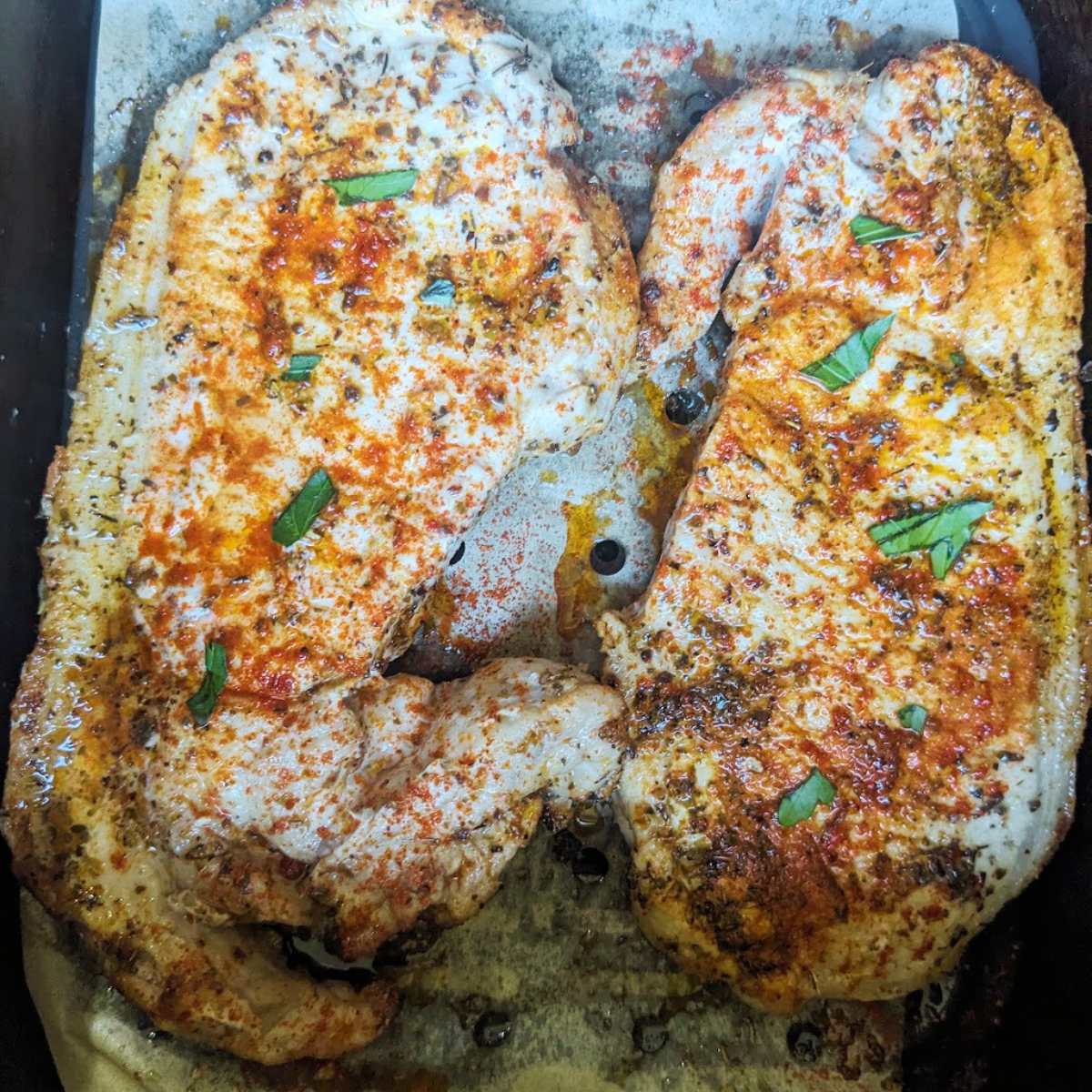 Two pork chops in an air fryer basket