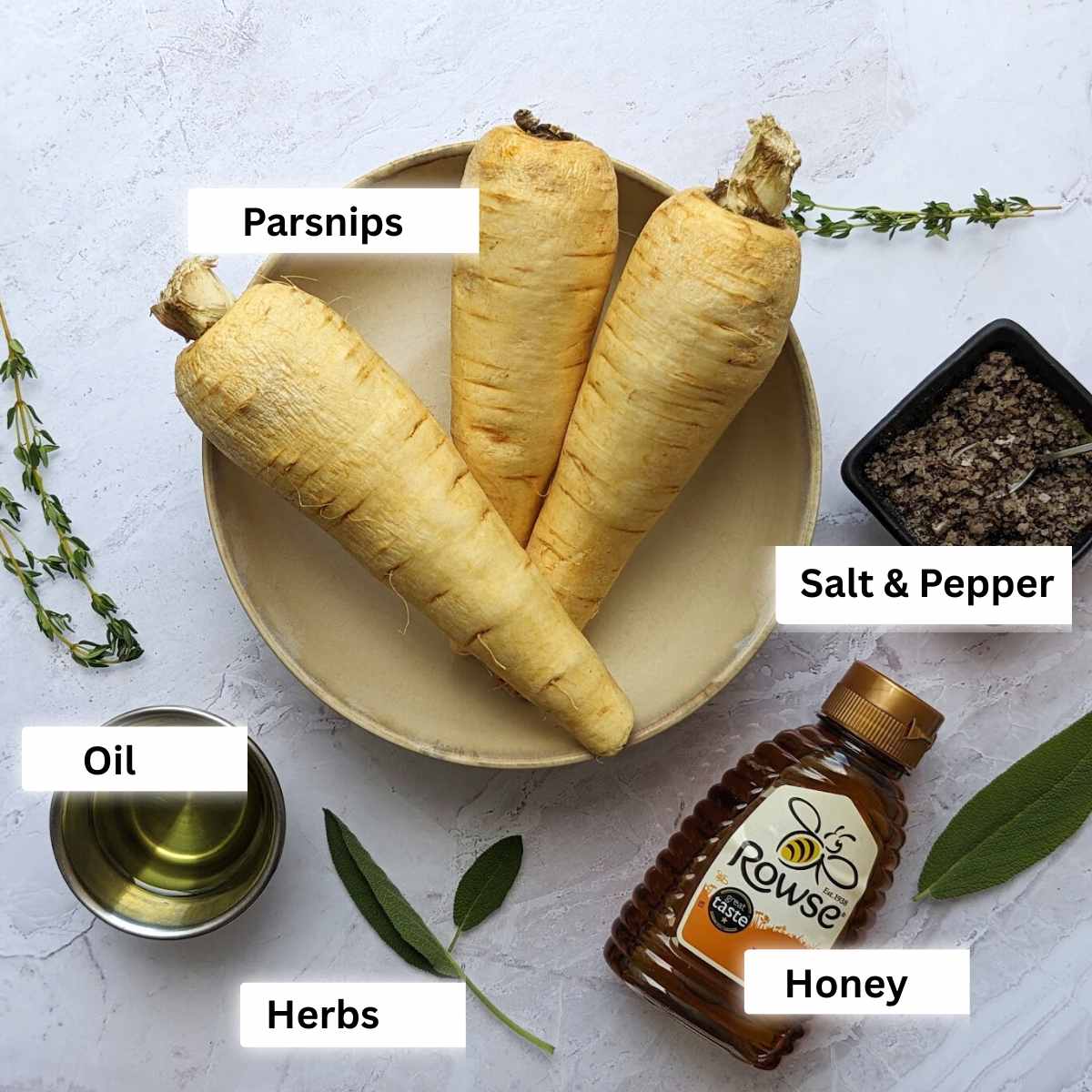 Ingredients for air fryer roasted parsnips including parsnips, oil, honey, salt and pepper and fresh herbs.