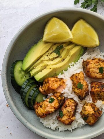 Air fryer salmon bowl with salmon bites, rice, avocado and cucumber