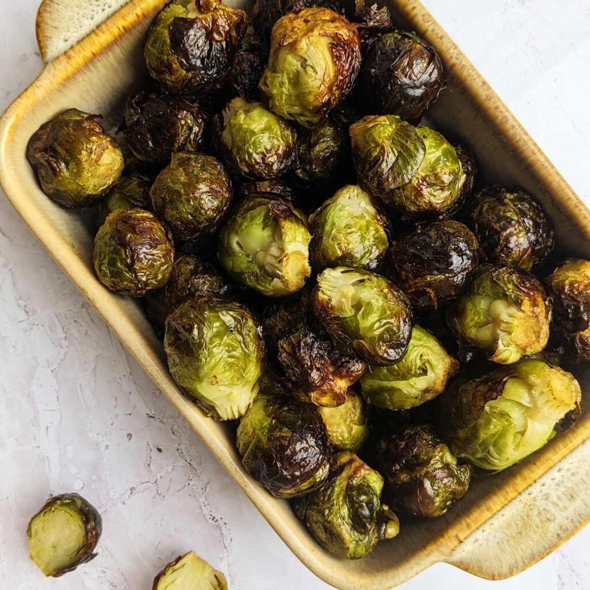 A serving dish filled with air fried Brussels sprouts.