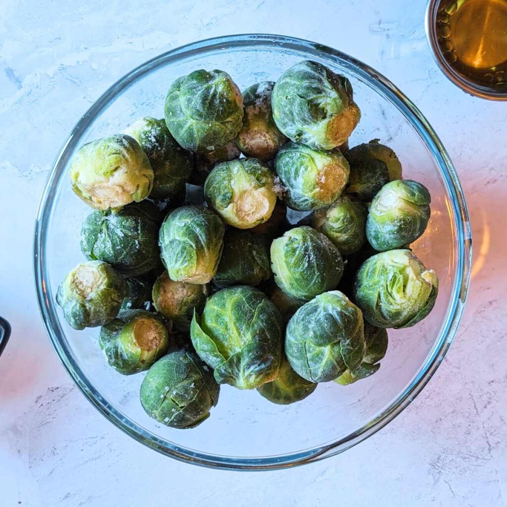 Frozen Brussels sprouts in a glass bowl.