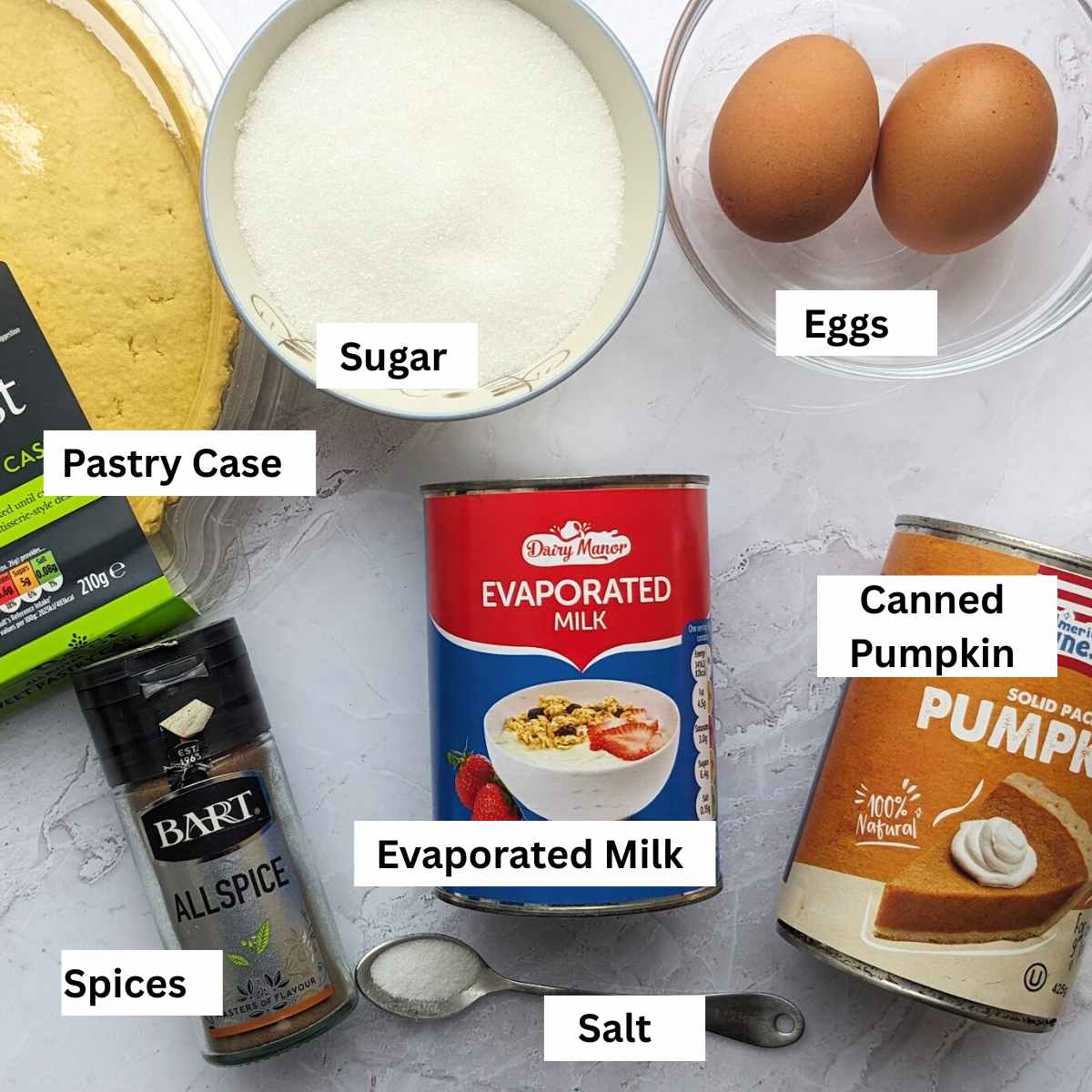 Ingredients for spicy pumpkin pie recipe including a ready-made pastry case, sugar, two eggs, allspice, evaporated milk, canned pumpkin and salt.